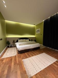 a bedroom with a bed and a green wall at شقة مروج هاوس دخول ذاتي in Hail
