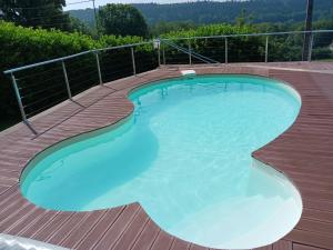 a large swimming pool on a wooden deck at La R'mise de Surcey in Alaise