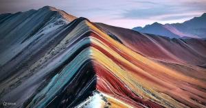 a rainbow colored mountain with mountains in the background at Paraiso Poroy in Cusco