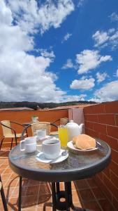a table with food and drinks on a patio at Paraiso Poroy in Cusco