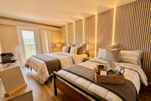 a hotel room with two beds and a window at Tremblant Ski Condo, Fast WIFI & Free parking in Mont-Tremblant