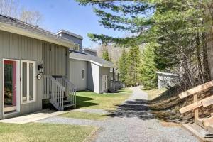 a walkway leading to a building with trees at Tremblant Ski Condo, Fast WIFI & Free parking in Mont-Tremblant