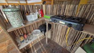 a kitchen with a stove in a wooden wall at Ecologic Mountain Cabin, amazing view in Santa Marta