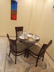 a dining room table with chairs and a table with cups and plates at Kaisa garden in Nairobi