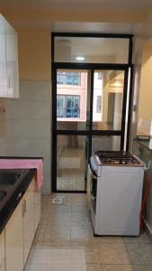 a kitchen with a stove and a window in it at Kaisa garden in Nairobi