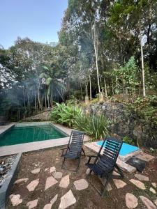two chairs sitting next to a swimming pool at Imperial Rodrigues Valley in Juquitiba