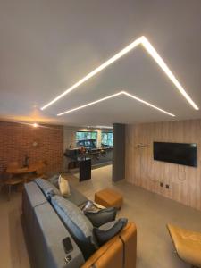 a large living room with a couch and a tv at Imperial Rodrigues Valley in Juquitiba