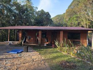 a small brick house in the middle of a field at Imperial Rodrigues Valley in Juquitiba