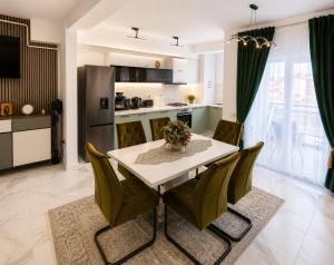 a kitchen and dining room with a table and chairs at Zori de Bucovina Apartament in Gura Humorului