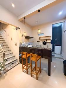 a kitchen with two wooden stools and a counter at Tafufu Villa Tumpak Sewu in Sumberbopong