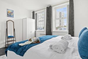 a bedroom with a bed with towels and a mirror at Cheshire Dimond one bedroom flat in Warrington in Warrington