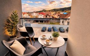 a balcony with a table and chairs and a view of a parking lot at Zori de Bucovina Apartament in Gura Humorului