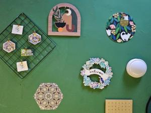 a green wall with wreaths and pictures on it at Hotel SN Legacy in Kuala Terengganu