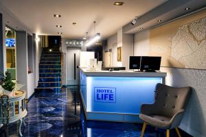 a hotel life lobby with a counter and a chair at City Life Port Hotel in Heraklio