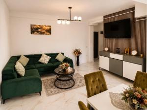 a living room with a green couch and a table at Zori de Bucovina Apartament in Gura Humorului