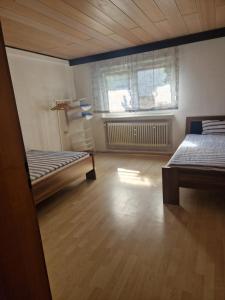 an empty room with two beds and a window at Monteurenwohnung Chez Danou in Idar-Oberstein