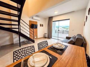a living room with a dining table and a staircase at Loft Novo e Completo no Centro • 4 Pessoas in Brusque