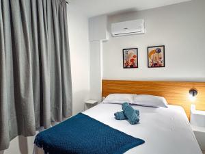a bedroom with a bed with a blue stuffed animal on it at Loft Novo e Completo no Centro • 4 Pessoas in Brusque
