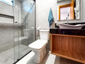 a bathroom with a shower and a toilet and a sink at Loft Novo e Completo no Centro • 4 Pessoas in Brusque +17 photos
