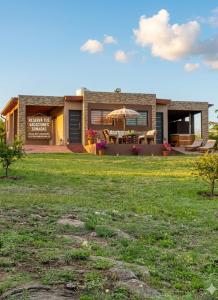 a house with a patio and an umbrella in a yard at Complejo Renacer in Villa Parque Siquiman