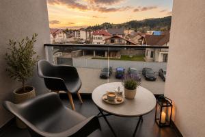 a balcony with a table and chairs and a view of a city at Zori de Bucovina in Gura Humorului