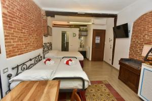two beds in a room with a brick wall at The Vernazza Main Plaza - Rooms & Suites in Vernazza