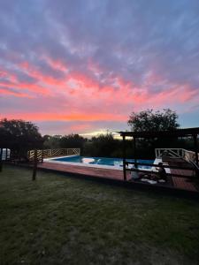 a swimming pool with a sunset in the background at Complejo Renacer in Villa Parque Siquiman