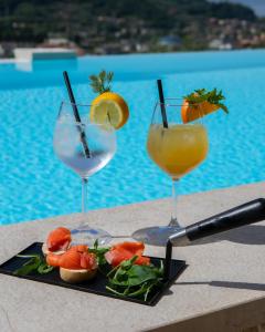 three drinks on a tray next to a pool at Relais Villa Olivi in Costermano