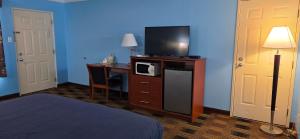 a hotel room with a bed and a desk with a television at Fontana Village Inn in Lake Geneva