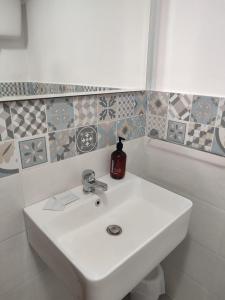a white sink in a bathroom with tiles at Casa Francesca Ponza in Ponza +37 photos