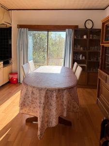 a table and chairs in a room with a window at Oyado Nishiki in Minamiizu