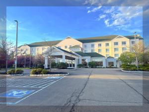 an empty parking lot in front of a large building at Arnot Grand Hotel & Suites in Horseheads