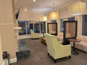 a living room with chairs and a couch at Arnot Grand Hotel & Suites in Horseheads