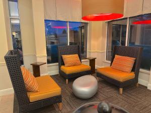 two chairs with orange cushions sitting in a room with windows at Arnot Grand Hotel & Suites in Horseheads +21 photos