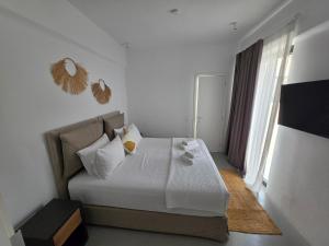 a bedroom with a bed with white sheets and pillows at Aura Sun Villa in Agios Romanos +9 photos