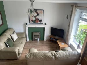 a living room with a couch and a television at Eirlys in Caernarfon