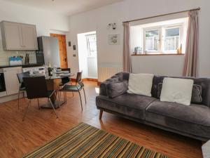 a living room with a couch and a table at Swallows Retreat in Kilgetty