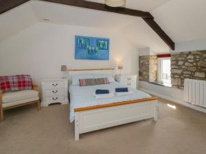 a bedroom with a bed and a chair at Swallows Retreat in Kilgetty