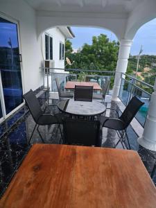 a patio with tables and chairs on a balcony at Cape Coast Travellers' Inn in Cape Coast