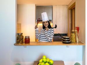 a woman in a chefs hat is holding a knife at Adagio Jeddah City Center in Jeddah +122 photos