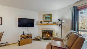 a living room with a fireplace and a flat screen tv at Downtown McCall Condo with Balcony & Views in McCall