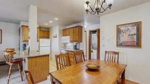a kitchen and dining room with a wooden table and chairs at Downtown McCall Condo with Balcony & Views in McCall +9 photos