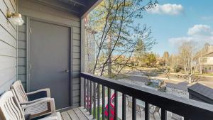 a porch with two chairs and a sliding glass door at Downtown McCall Condo with Balcony & Views in McCall