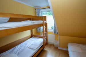 zwei Etagenbetten in einem Zimmer mit Fenster in der Unterkunft Skutskepparn Kuststation in Nordingrå