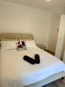 a white bed with two black socks on it at O Refúgio dos Ferreiros in Guarda