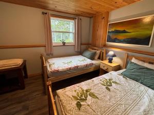 a bedroom with two beds and a window at Sunrise Place Bed & Breakfast in DʼEscousse