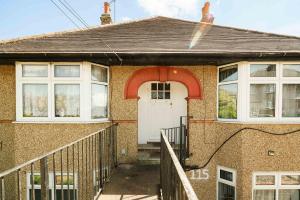 a brick house with a white door and a porch at Swingate Lane Stay in Plumstead
