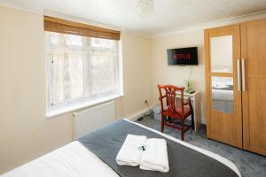 a bedroom with a bed and a chair and a desk at Swingate Lane Stay in Plumstead