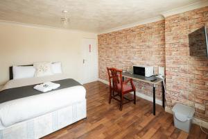 a bedroom with a bed and a desk with a computer at Swingate Lane Stay in Plumstead