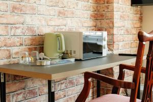 a microwave sitting on a table with a brick wall at Swingate Lane Stay in Plumstead